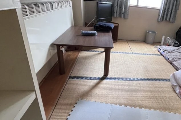 和室の寮の部屋の画像。畳敷きの空間にテーブルとテレビ、暖房器具が置かれ、生活感がある。リゾートバイト中の落ち着いた居住空間。