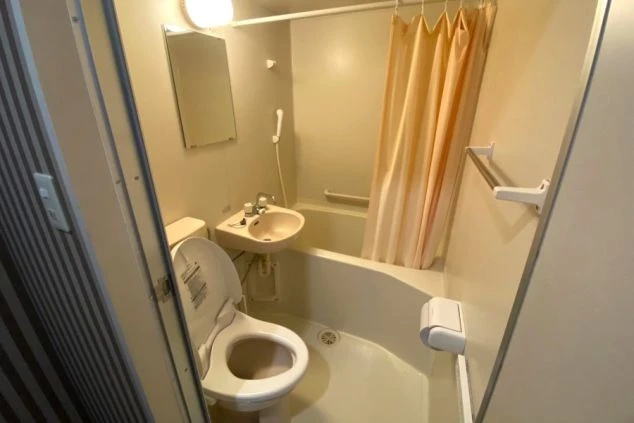 トイレと洗面台、浴槽が一体となったリゾートバイトの寮のユニットバスの画像。