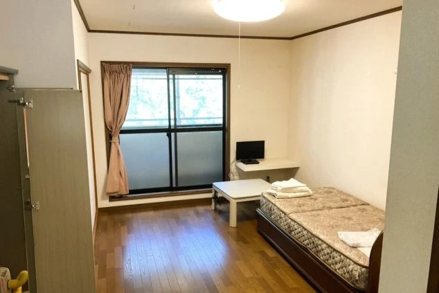 リゾートバイトの個室寮の部屋の画像。キレイで広々としている。ベッド・TV・テーブル・収納が見える。