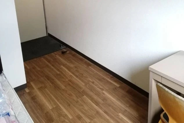 リゾートバイトの個室寮の室内。フローリング仕様で清潔感のある、一人暮らしに十分な広さの居室イメージ。