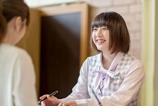 リゾートバイトで、お客様を笑顔で迎えるフロントスタッフの画像。