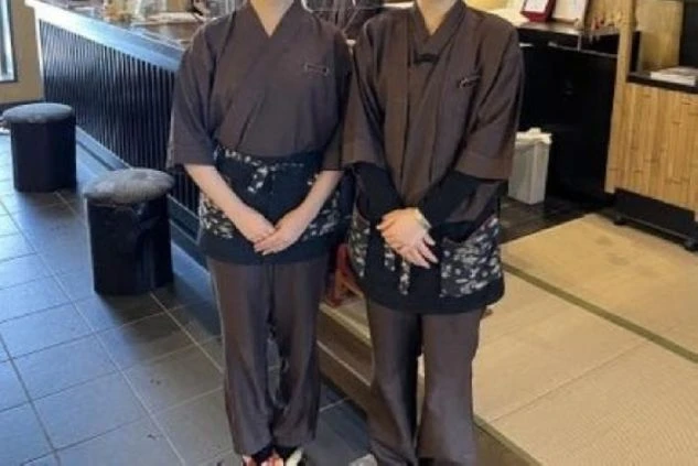 男女共通の作務衣の制服画像。茶色と黒のカラーでシックな印象。