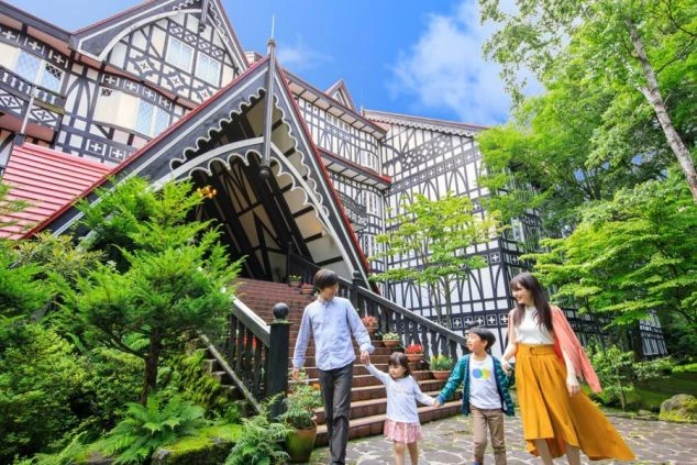 花や緑の中を歩く人々。テーマパークや庭園でのリゾートバイトの休日の散策。