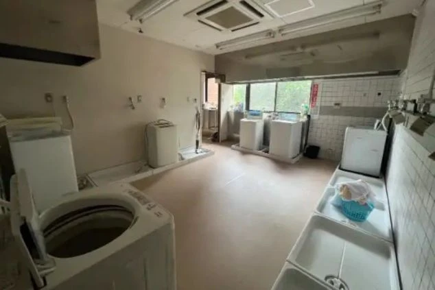 複数の洗濯機とシンクが備え付けられた、広々とした共同ランドリーの画像