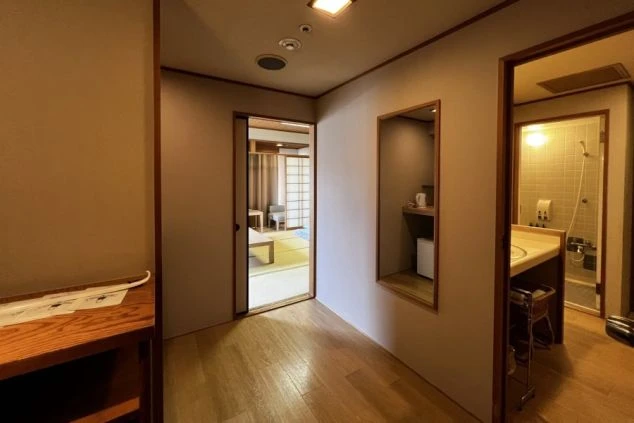 寮の部屋の入り口付近の画像。廊下から和室、洗面所、浴室が見える。