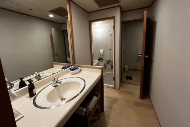 寮の部屋の画像。和室で、押入れ、座卓、布団が見える。