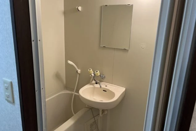 ワクトリの社員が出張で撮影した、リゾートバイトの寮のユニットバスの画像。浴槽、シャワー、洗面台がコンパクトにまとまっており、鏡も見える。シンプルで機能的なリゾートバイト中の水回り設備。