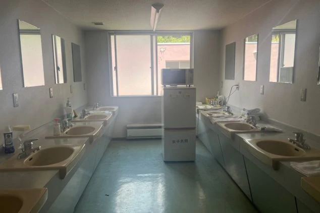 洗面台や電子レンジ、冷蔵庫がある寮の共有スペース。快適な共同生活を送れます。