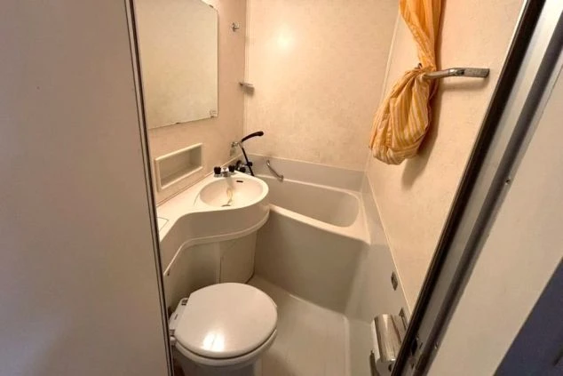 リゾートバイトの個室寮にあるユニットバスの写真。浴槽、トイレ、洗面台が一体となった清潔なプライベート空間のイメージ。