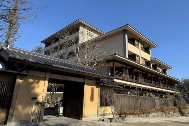 和風の屋根瓦を持つ大規模なリゾートホテルの外観画像。山間部の温泉地や旅館でのリゾートバイトの勤務地のイメージを伝える。