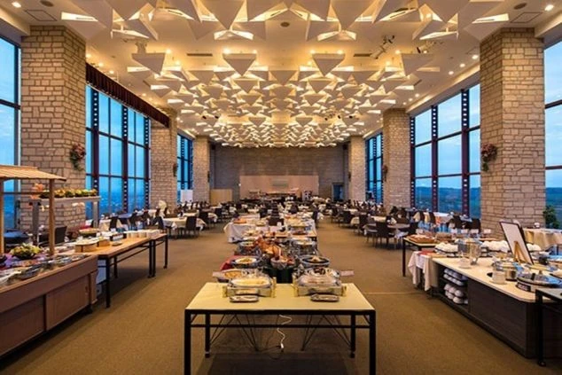 リゾートバイトの勤務先となる、豪華なリゾートホテルのレストラン。天井が高く、開放的な空間で、配膳や接客のスキルを磨けます。