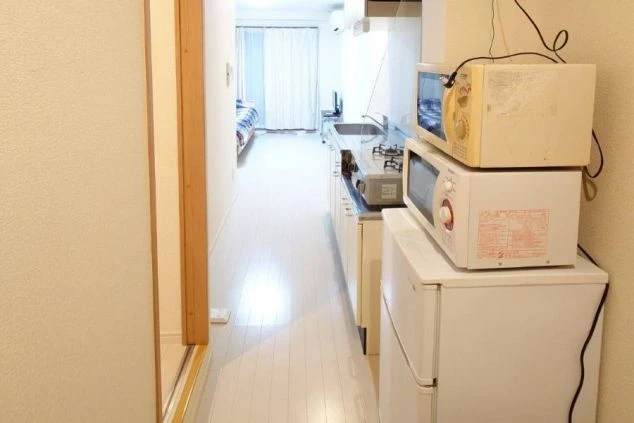 リゾートバイトの寮にあるキッチンスペース。冷蔵庫、電子レンジ、ガスコンロが完備され、自炊生活に便利な環境。