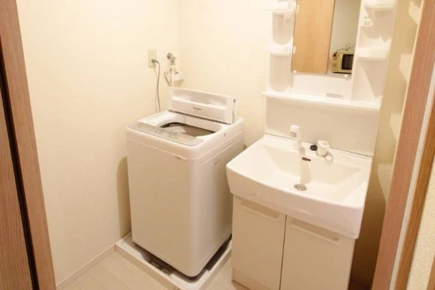 リゾートバイトの寮にある洗面台と洗濯機。生活に必要な水回りの設備が充実しており、安心して自炊や洗濯ができる。