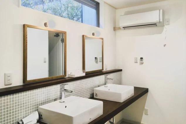 築浅シェアハウスの洗面所。大きな鏡とエアコン完備で快適