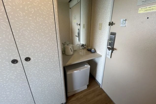 リゾートバイトの寮の部屋の入り口付近を撮影した画像。クローゼットと、その隣には冷蔵庫や電気ケトルが備え付けられている。リゾートバイトの寮の部屋の画像。
