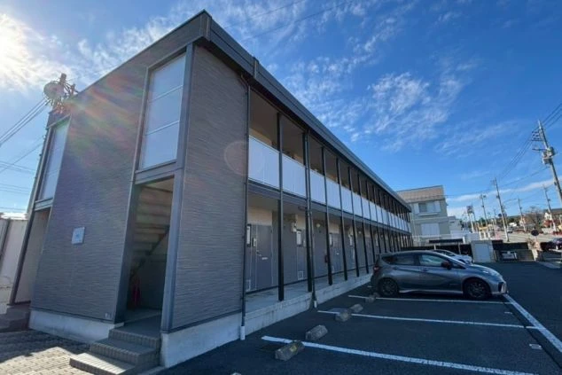 青空の下に建つ、モダンで綺麗な2階建てアパートタイプのリゾートバイト専用寮。駐車場完備でマイカー持ち込みも可能な、安心の住み込み拠点。