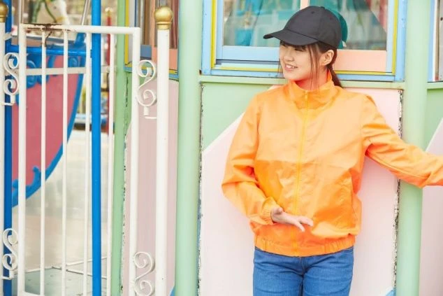 カラフルな遊具の前に立つスタッフ。お客様に笑顔で接客する、活気のある職場です。