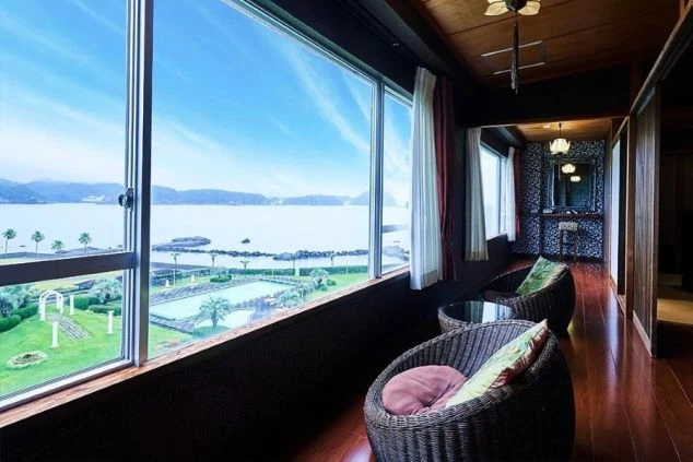 窓一面に海と庭園が見える絶景の客室・リラックススペースの画像。