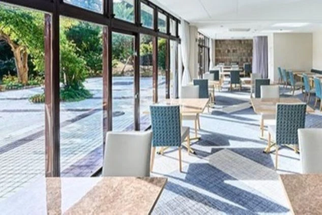 窓から緑が見える明るくモダンなホテルレストランの画像。リゾートバイトのホールスタッフやレストラン業務の職場環境。