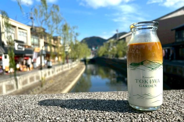 夕暮れ時、暖かな光に照らされた風情ある高級旅館の外観。手入れの行き届いた庭と石畳のアプローチが、落ち着いた上質な空間へと誘う。