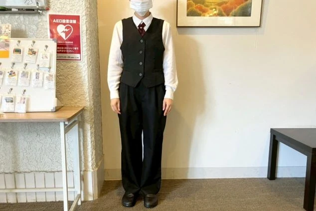 レストランの制服写真。白いシャツに黒のベストを着用。