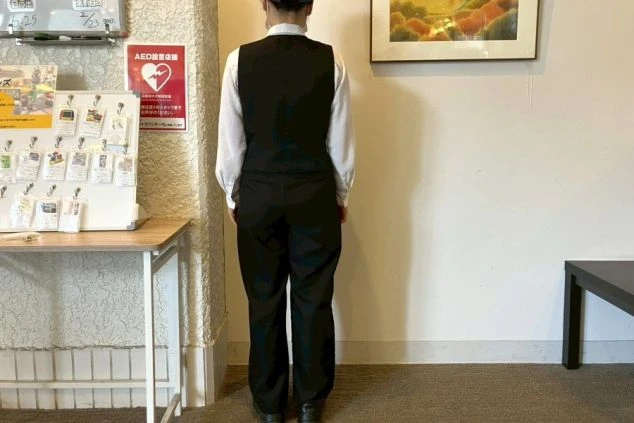 レストランの制服写真。白いシャツに黒のベストを着用した後ろ姿。