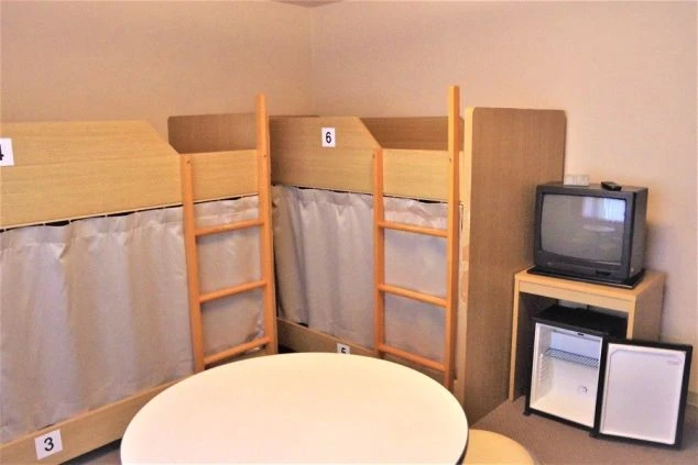 リゾートバイトの寮に完備された、複数のベッドがある相部屋。テレビや冷蔵庫もあり、共同生活の思い出作りも可能。