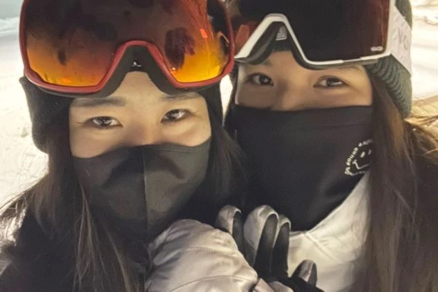 スキー・スノーボードウェアを着た若者二人。リゾートバイトの休日に冬のアクティビティを楽しむ友達。