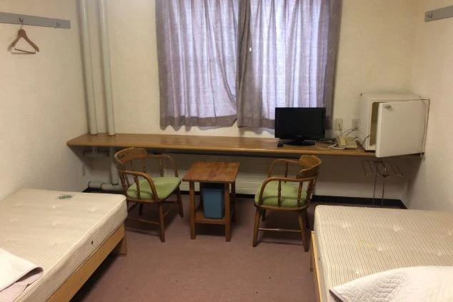 リゾートバイトの寮の部屋の画像。ベッドやテレビ、机などが完備されている。