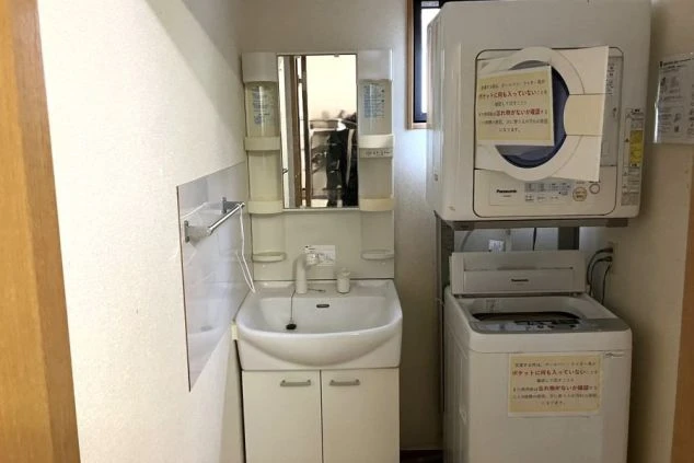 リゾートバイトの男性寮の共用スペース。洗面台と、乾燥機付きの洗濯機が設置されている。