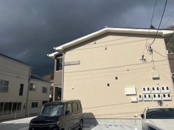 寮の外観。車が停まる建物の入り口が映る。