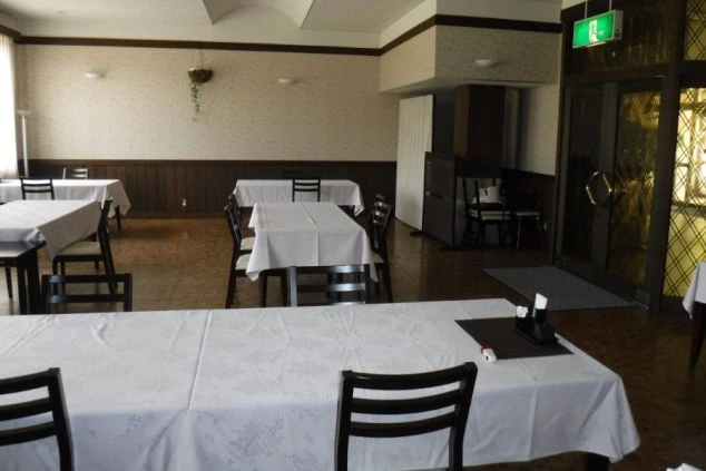 リゾートバイトの寮の共用ダイニング。白いテーブルクロスがかかった清潔な空間で、毎日の食事をとることができます。