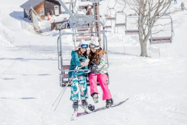 リフトの上で記念撮影をするリゾートバイト仲間。仕事の合間や休日にゲレンデでリフレッシュ。