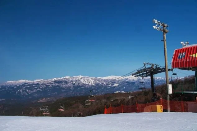 快晴のスキー場から望む絶景の雪山。リゾートバイトの休日に、ウィンタースポーツを満喫できるイメージ。