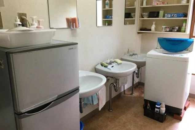 リゾートバイトの寮にある共同洗面所。洗濯機や冷蔵庫も設置され、生活に必要な設備が充実している。