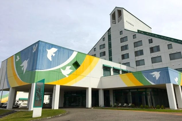 リゾートバイトで出会ったカップルが、スキー場で自撮りを楽しむ様子。冬のリゾート地で、仕事もプライベートも充実した毎日。