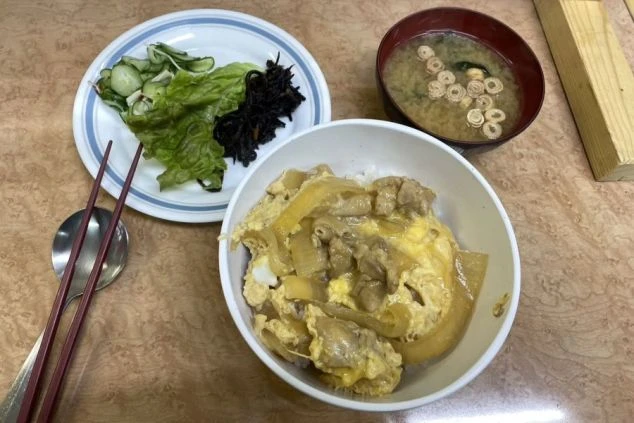 リゾートバイトの賄いの食事。親子丼と味噌汁、サラダが揃った、バランスの良い美味しい定食。