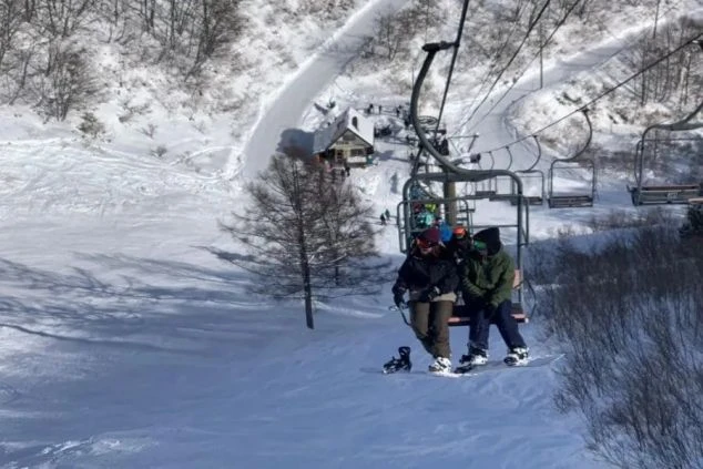 スキー場のリフトに乗るリゾートバイト仲間。冬のリゾート地で働き、休日にはウィンタースポーツを楽しむ充実した毎日。