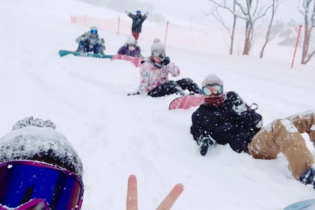 雪が降るゲレンデで、リゾートバイトの仲間たちと記念撮影。吹雪の中でも、みんなでスノーボードを楽しんでいます。