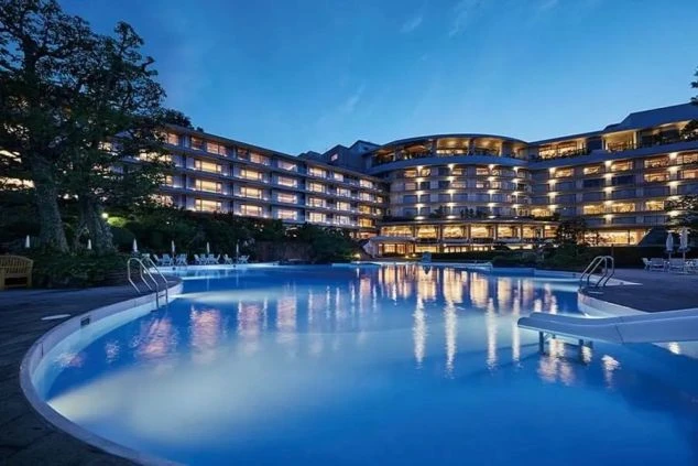 美しいナイトプールとホテル全景。リゾートバイトで、お客様に最高の夏休みを提供するホテルの仕事