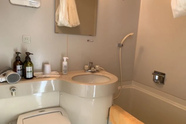 リゾートバイトの社員寮の部屋を表現するイメージ画像。浴槽とシャワー、洗面台とトイレが一体となったユニットバス。
