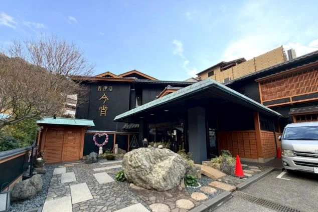 窓越しに海が見える温泉の浴槽の画像です。湯気が立ち上り、温泉の温かさが伝わります。木々も見えることから、自然に囲まれた場所でのリゾートバイトの仕事終わりに温泉で疲れを癒すイメージ