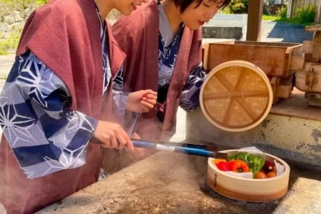 ワクトリの社員が撮影した、熊本県の鍋ヶ滝の画像。女性が滝の裏側から滝を見ている。