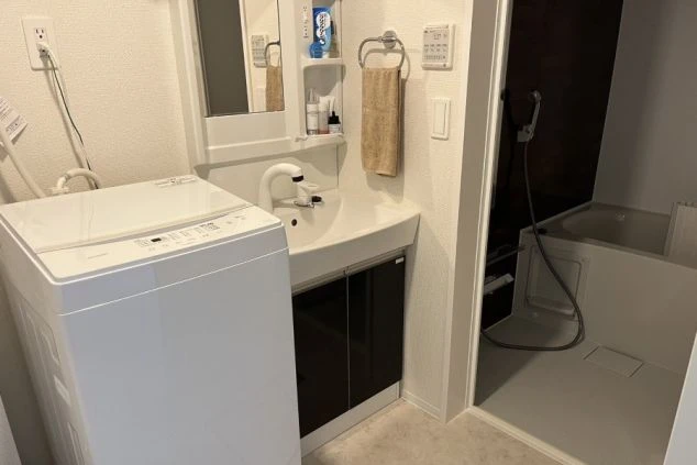 リゾートバイトの寮にある洗濯機と独立洗面台の画像。部屋に完備された充実した水回り設備。