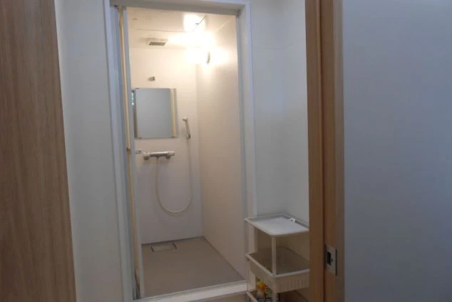 リゾートバイト寮にあるシャワールームの画像。鏡とシャワー設備があり、清潔感がある。