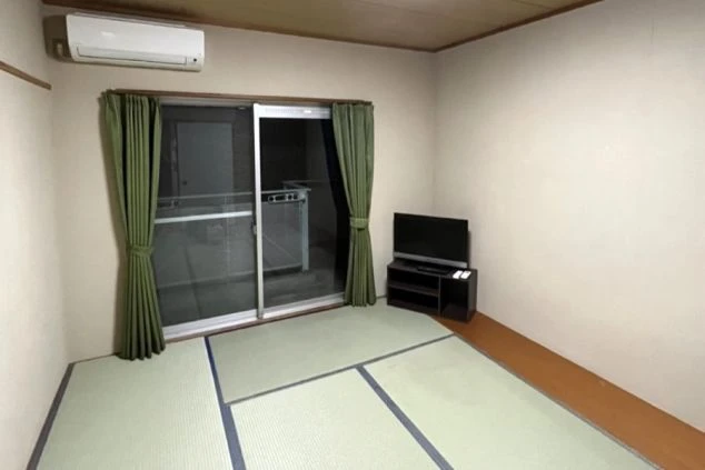 窓から光が差し込むリゾートバイトの寮の部屋。和室タイプの個室で、生活に必要な設備が揃い、新生活も安心。