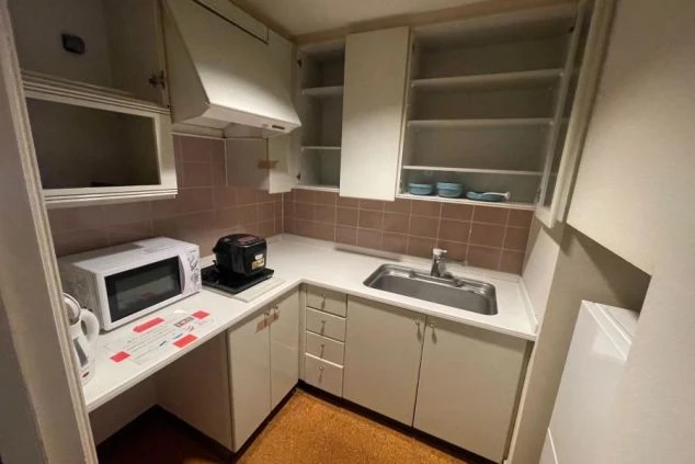 リゾートバイト寮のミニキッチン。電子レンジ、炊飯器、シンクが備え付けられており、自炊可能。収納も多い。