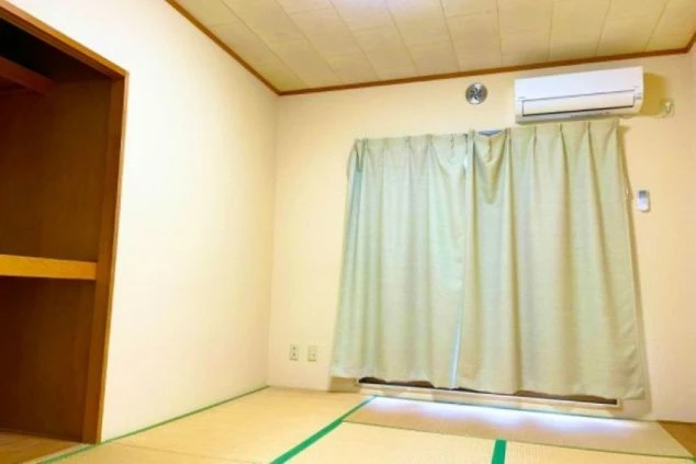 畳敷きの部屋で、エアコンとクローゼットが見える。落ち着いた和の空間でくつろげることをアピール。