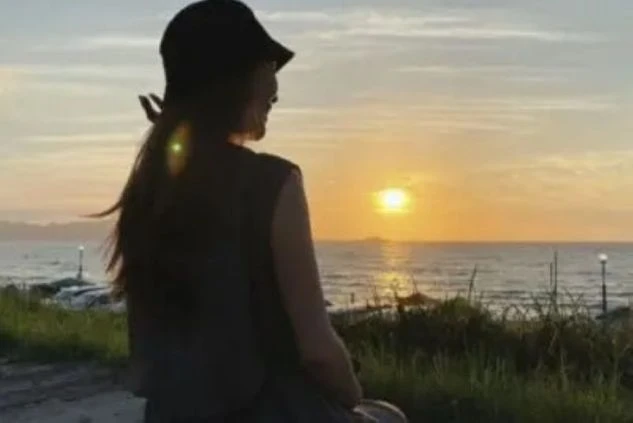 穏やかな海に沈む美しい夕日を眺める女性の後ろ姿。リゾートバイトの仕事を通して、このような絶景を身近に感じ、仕事の疲れを癒せる魅力を伝えます。