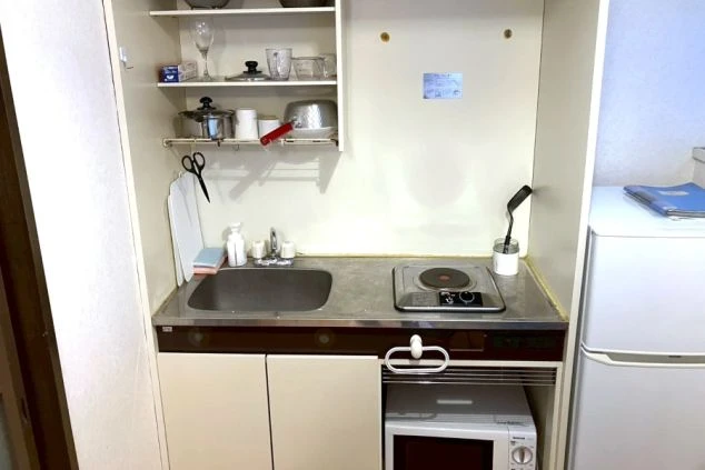 寮に完備されたミニキッチン。IHコンロ、電子レンジ、冷蔵庫付きで自炊が可能。